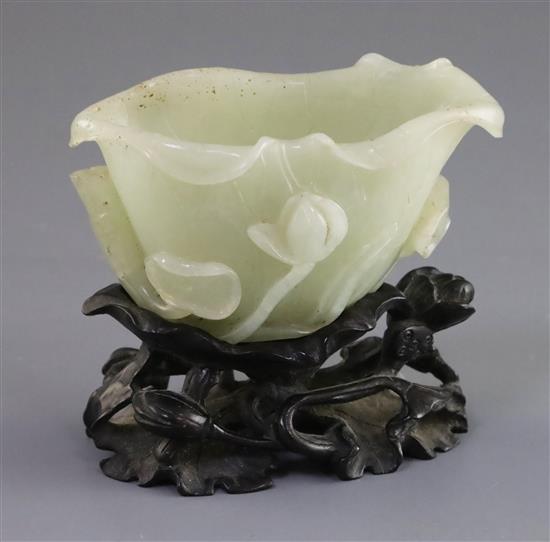 A Chinese pale celadon jade lotus brushwasher, 18th/19th century, L. 9.7cm, carved wood lotus stand